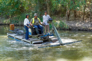 Barco anfibio en río Henares cortando plantas en Torrejón