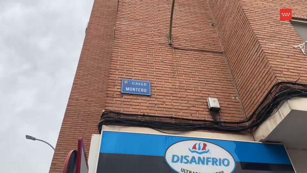 Placa de calle con el nombre "Calle Montero" en una fachada de ladrillo y un establecimiento cuyo nombre es "DISANFRIO" en Mó