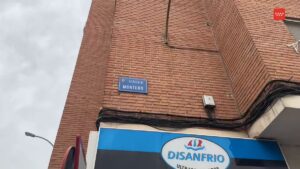 Placa de calle con el nombre "Calle Montero" en una fachada de ladrillo y un establecimiento cuyo nombre es "DISANFRIO" en Mó