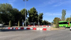 Avenida de Madrid en Alcalá de Henares con badenes, árboles y una fuente en el centro de la rotonda.