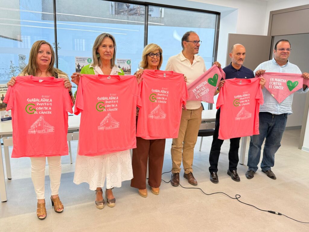 Grupo de seis personas sosteniendo camisetas rosas con el lema "Guadalajara juntos contra el cáncer" en Guadalajara.