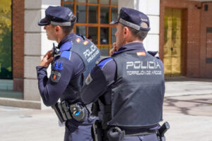 Dos policías enfocados de espaldas, con uniforme y chalecos que indican "Policía Torrejón de Ardoz", en una calle de la ciuda