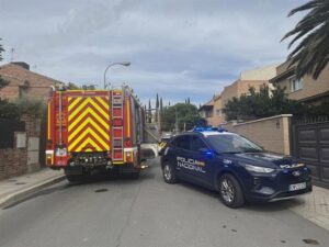 Vehículos de emergencias en una calle residencial de Pozuelo de Alarcón, con un camión de bomberos y un coche de policía.