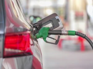 Manguera de gasolinera repostando un coche; la rebaja de la gasolina de 20 céntimos se mantiene en noviembre